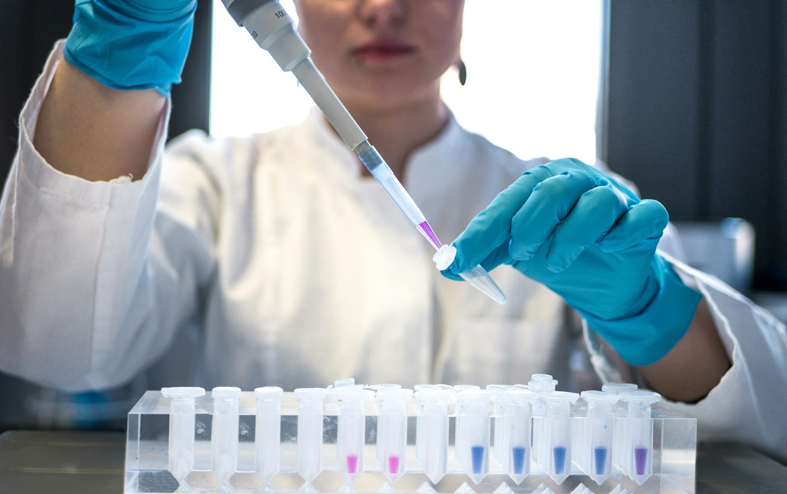 A scientist working with a pipette; illustrative research photography
